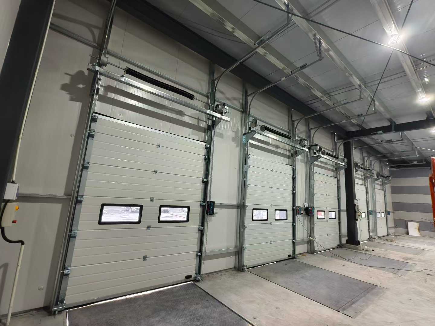 వేర్‌హౌస్ ప్రాజెక్ట్‌ల కోసం ఇండస్ట్రియల్ సెక్షనల్ డోర్స్ మరియు డాక్ లెవెలర్స్ షిప్‌మెంట్